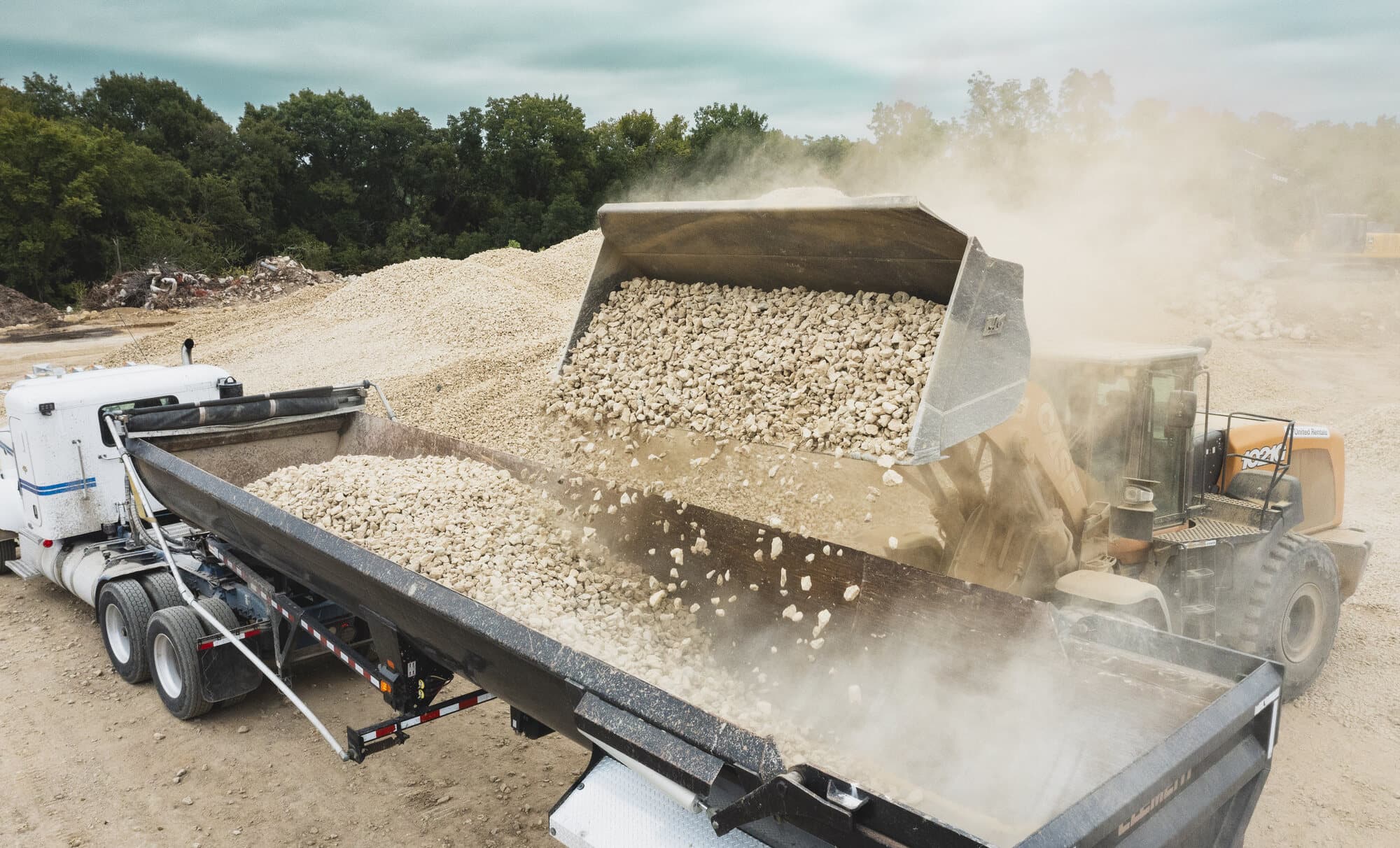 A wheel loader charging a haul truck from a screened stockpile