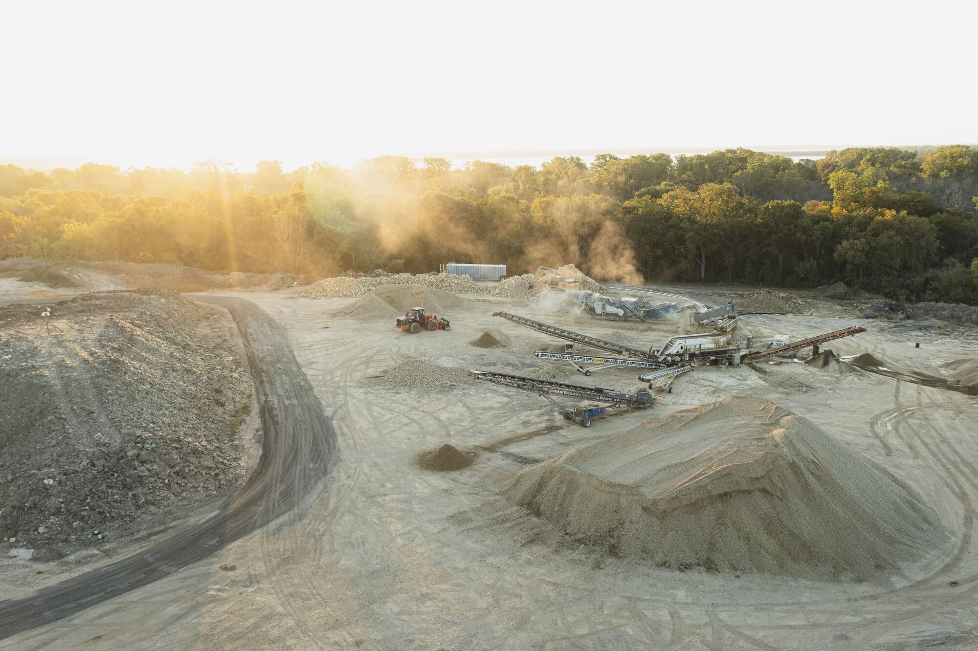 A crushing and screening spread with stacking conveyors working beside stockpiles